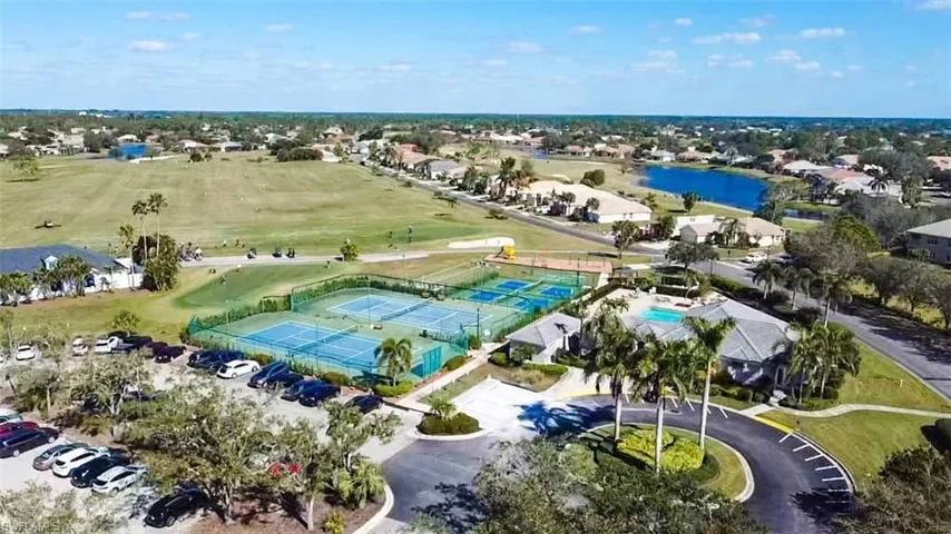 Aerial view of residential area featuring a nearby body of water and a local golf course