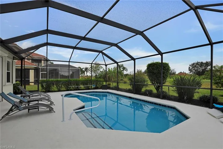 Outdoor pool featuring a sunroom, glass enclosure, and a patio area