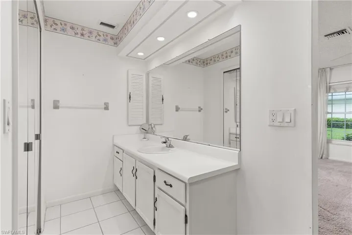 Bathroom with vanity, baseboards, and recessed lighting