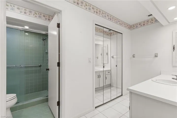 Bathroom with vanity, tile patterned floors, a stall shower, recessed lighting, and toilet