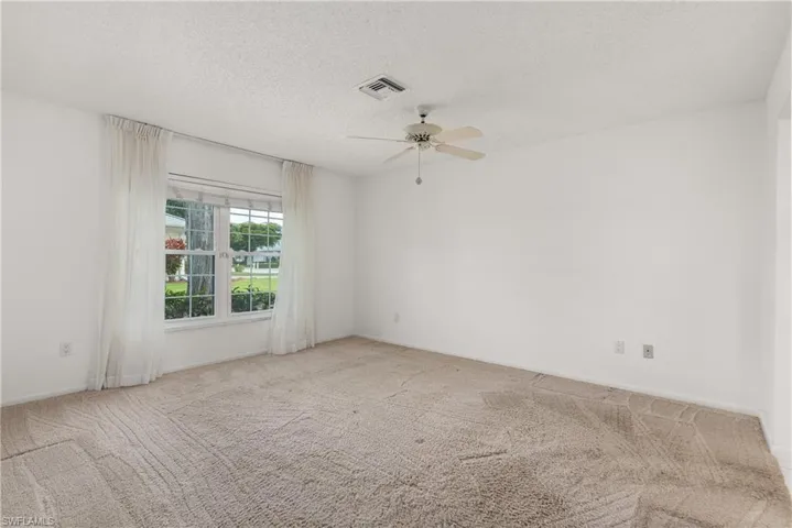 Unfurnished room featuring ceiling fan, carpet flooring, a textured ceiling, and baseboards