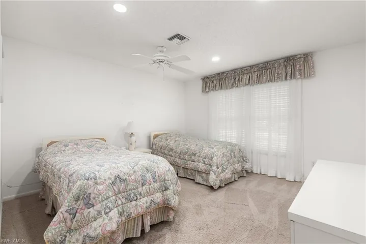 Bedroom with light colored carpet, recessed lighting, a ceiling fan, and baseboards
