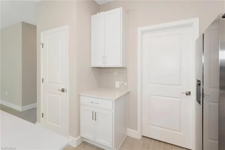 Kitchen with white cabinetry and backsplash