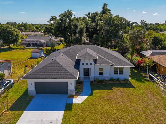 View of front of property featuring a garage and a front lawn