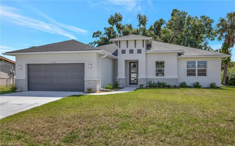 View of front facade featuring a garage and a front yard