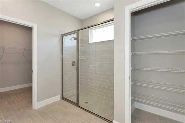 Bathroom featuring a shower with shower door and tile patterned floors