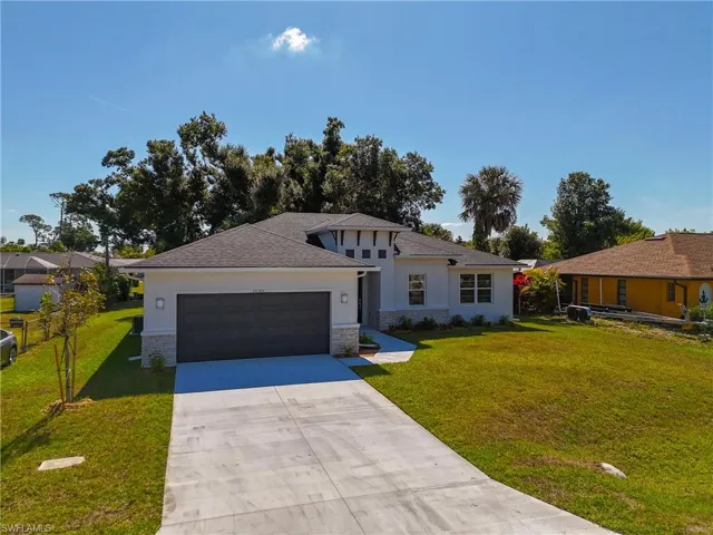 View of front of home with a garage and a front lawn
