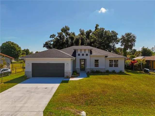 View of front of home with a garage and a front lawn
