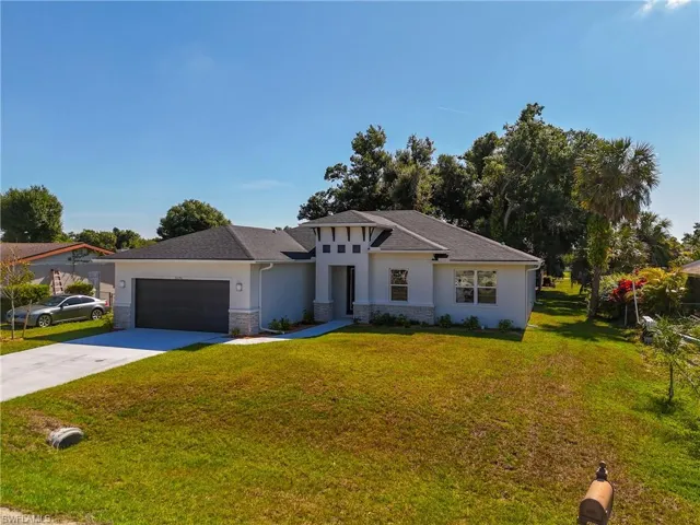 View of front of house featuring a garage and a front yard