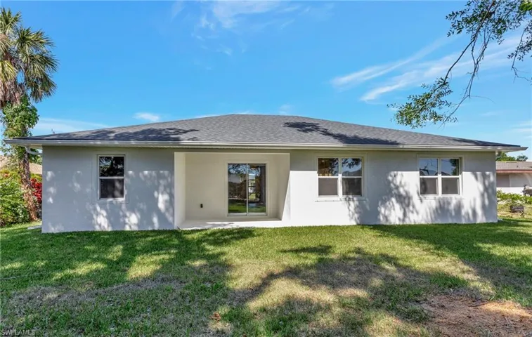 Rear view of property with a lawn