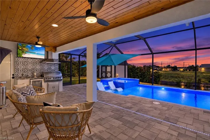 Covered outdoor living space with wood-finish ceiling and recessed lighting