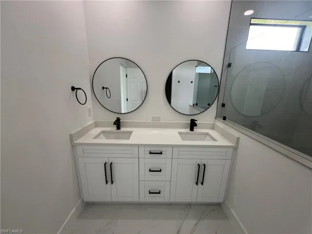 Bathroom featuring tile patterned floors and dual bowl vanity