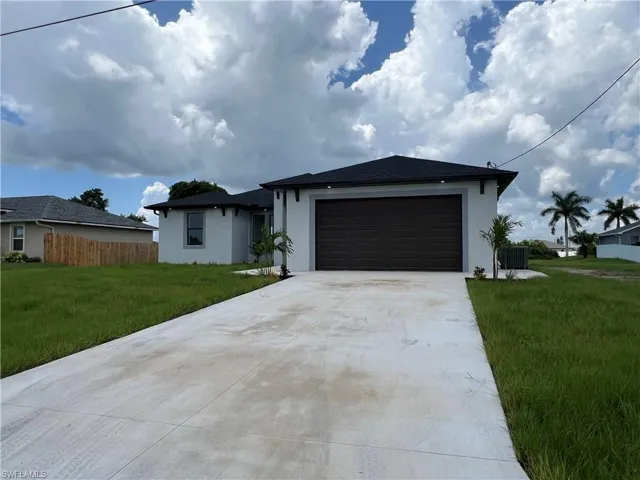 Ranch-style house with a garage, central AC, and a front lawn