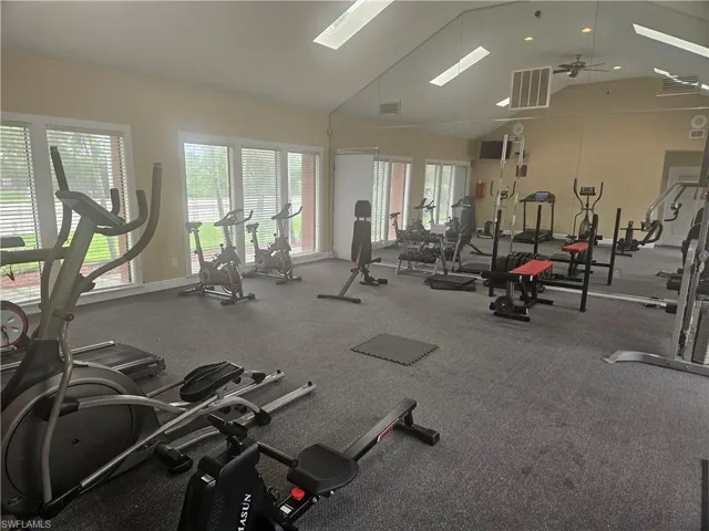 Workout area featuring high vaulted ceiling and ceiling fan