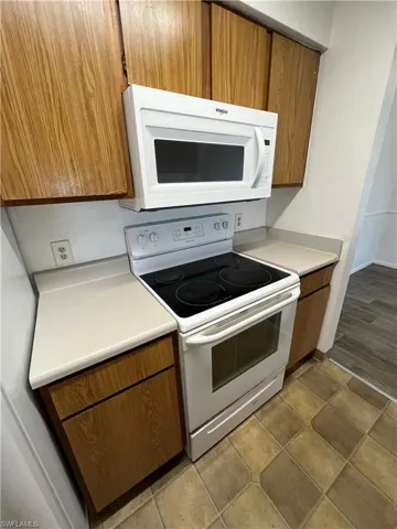 Kitchen featuring dark hardwood / wood-style floors and white appliances