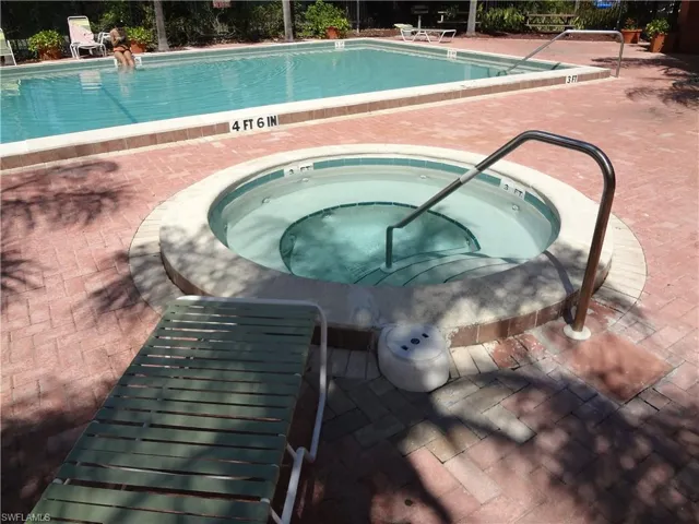 View of swimming pool with an in ground hot tub and a patio area