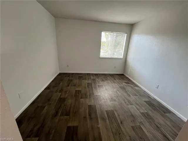 Empty room featuring dark hardwood / wood-style floors