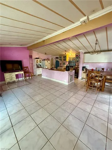 Living area with lofted ceiling and light tile patterned floors