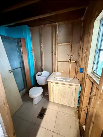 Full bathroom featuring vanity, a shower with shower door, and tile patterned flooring