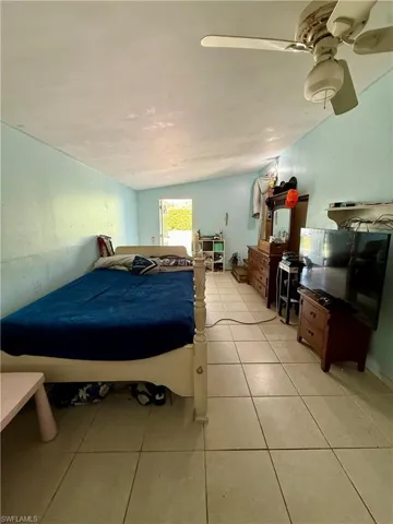 Bedroom with light tile patterned flooring and lofted ceiling