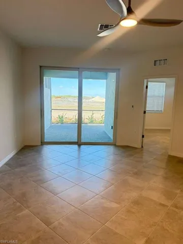 Unfurnished room featuring ceiling fan and light tile patterned flooring