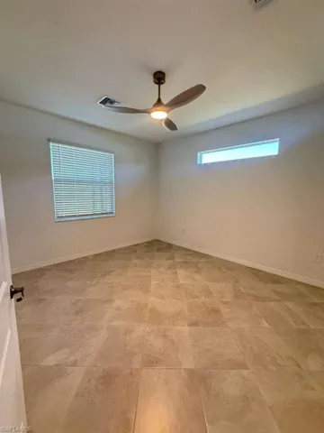 Spare room featuring baseboards and a ceiling fan