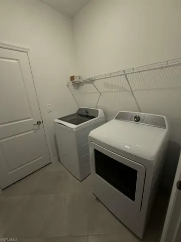 Laundry room featuring separate washer and dryer and light tile patterned floors