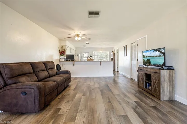 Living room with wood finished floors, ceiling fan, and baseboards