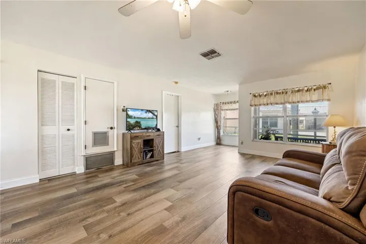 Living room with wood finished floors, a ceiling fan, and baseboards