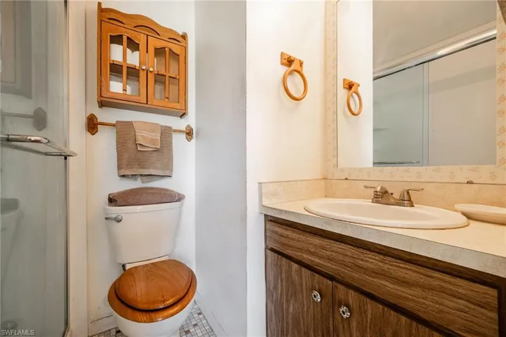 Full bathroom with a shower stall, toilet, and vanity