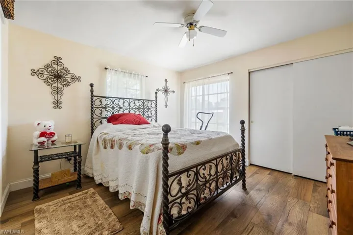 Bedroom featuring wood-type flooring, a closet, and a ceiling fan