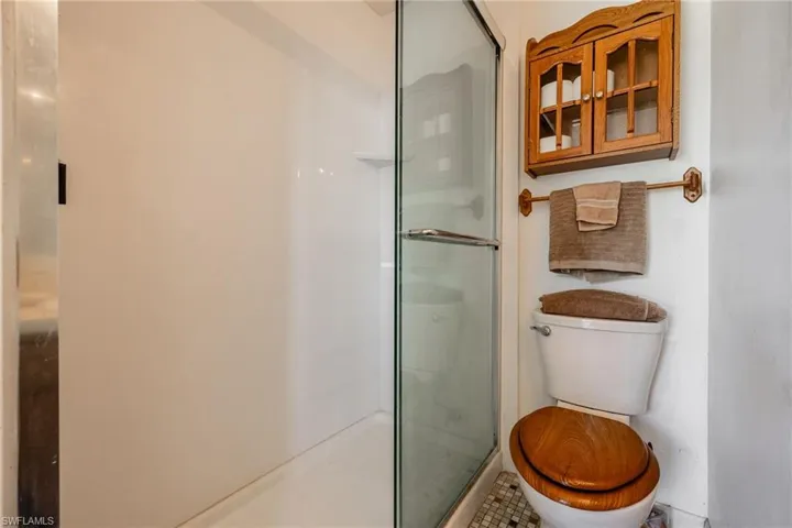 Full bathroom featuring a stall shower and toilet