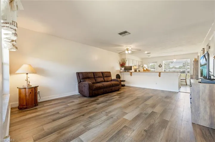 Sitting room with wood finished floors, ceiling fan, and baseboards
