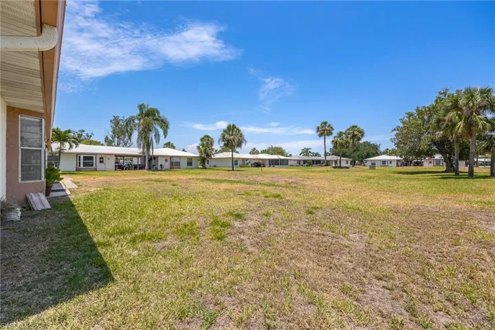 View of grassy yard with a carport
