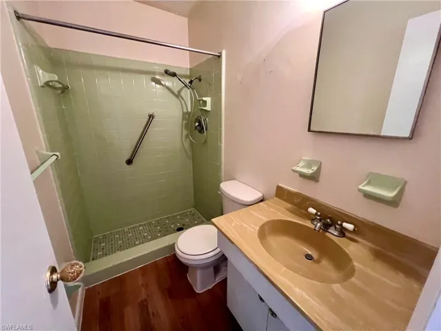 Bathroom with a tile shower, vanity, toilet.