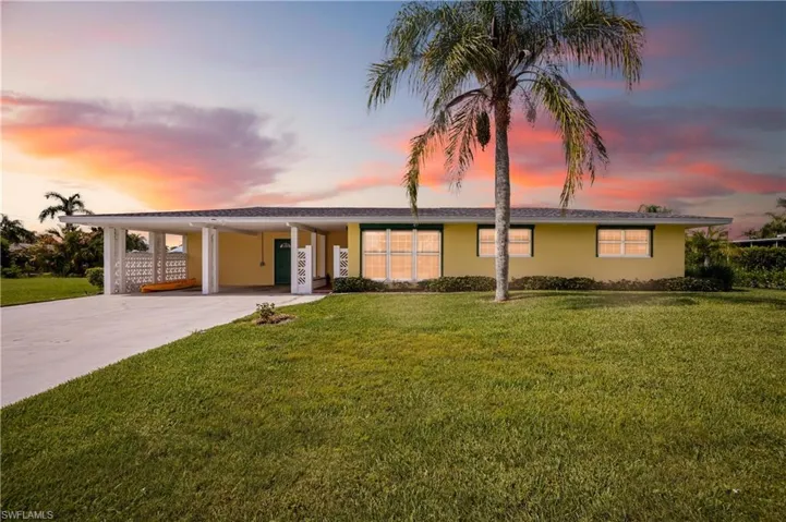 Single story home with a yard and a carport