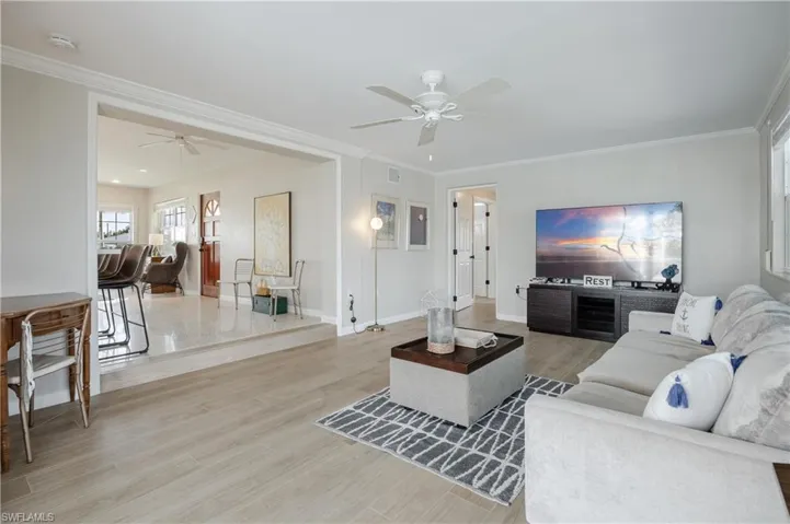 Living room featuring ceiling fan, hardwood / wood-style flooring, and ornamental molding