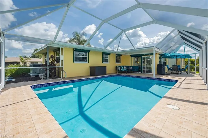 View of swimming pool featuring a lanai and a patio area