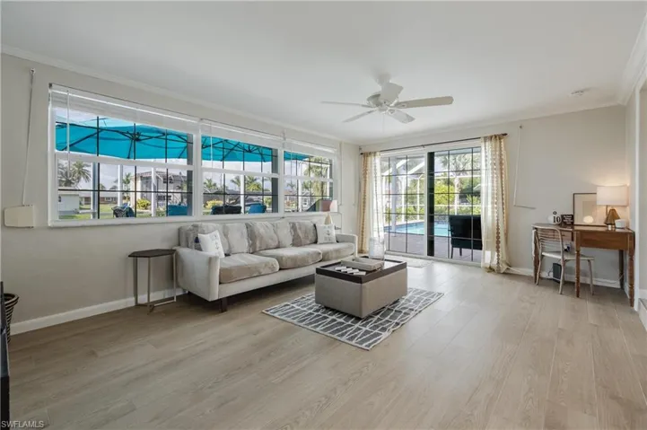 Living room featuring ceiling fan, light hardwood / wood-style flooring, and ornamental molding