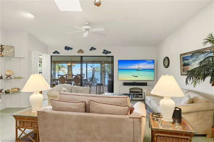Carpeted living room featuring a skylight and a ceiling fan