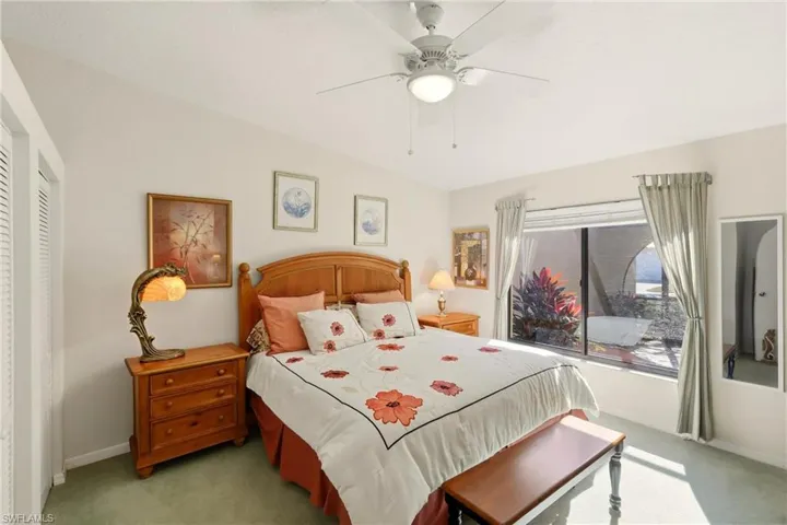 Carpeted bedroom featuring a ceiling fan and a closet