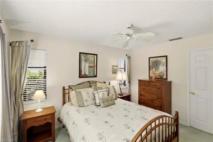 Bedroom featuring multiple windows, ceiling fan, and light colored carpet