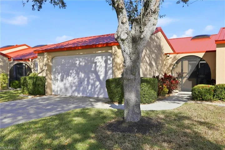 Mediterranean / spanish-style home with a metal roof, concrete driveway, stucco siding, an attached garage, and a front lawn