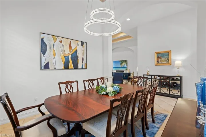 Dining room featuring recessed lighting, light tile patterned floors, baseboards, a towering ceiling, and arched walkways
