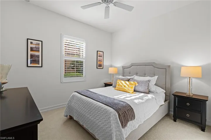 Bedroom with baseboards, a ceiling fan, and light colored carpet