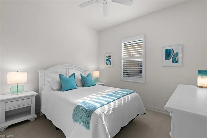 Bedroom featuring baseboards, light colored carpet, and ceiling fan