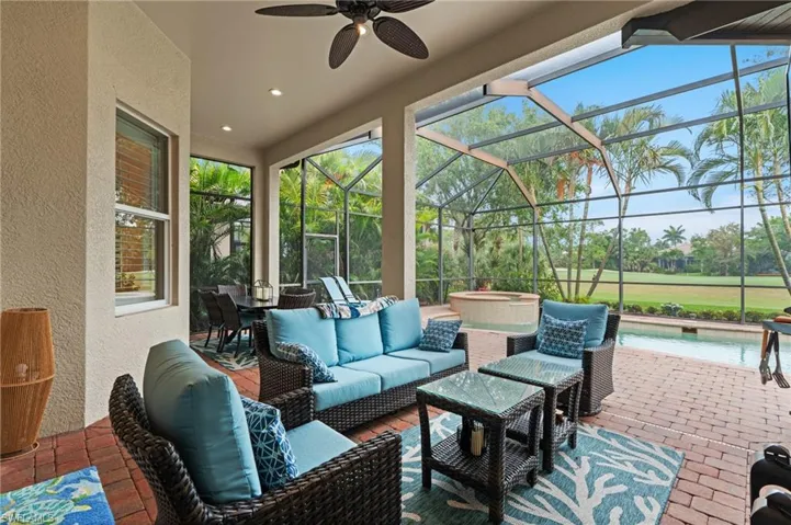 View of patio featuring an outdoor pool, an outdoor hangout area, glass enclosure, and ceiling fan
