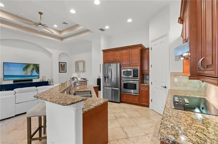 Kitchen with backsplash, a sink, a breakfast bar, open floor plan, and stainless steel appliances