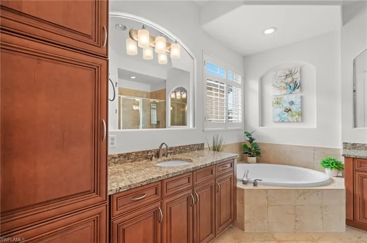 Bathroom with tile patterned flooring, vanity, a garden tub, and a shower stall