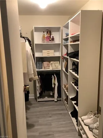 Walk in closet with light wood-style flooring